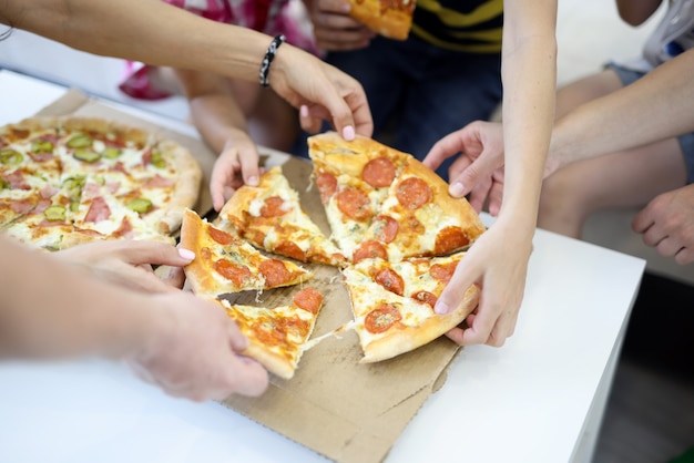 Deliziosa pizza tagliata a pezzi sul tavolo bianco