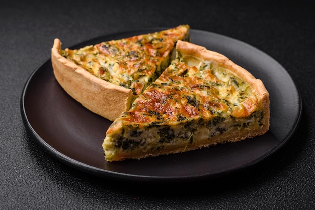 Deliziosa quiche fresca con spezie ed erbe di formaggio broccoli tagliate a pezzi su uno sfondo di cemento scuro