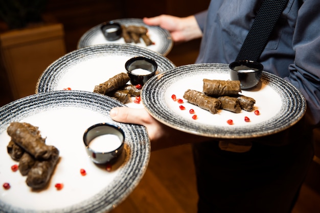 Deliziosa sarma dolma con vitello e bulgur. Carne di vitello con bulgur avvolto in foglie di vite. Servito con salsa bianca. Cibo per la cena. Cucina mediorientale greca turca.