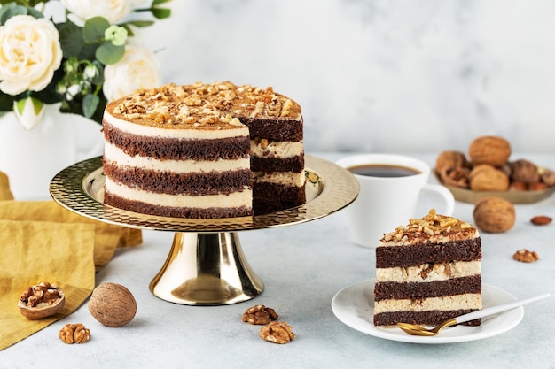 Deliziosa torta al cioccolato appena preparata con noci su un tavolo bianco su un supporto per dolci