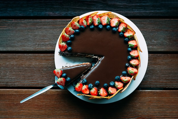 Deliziosa torta al cioccolato con frutti di bosco e glassa