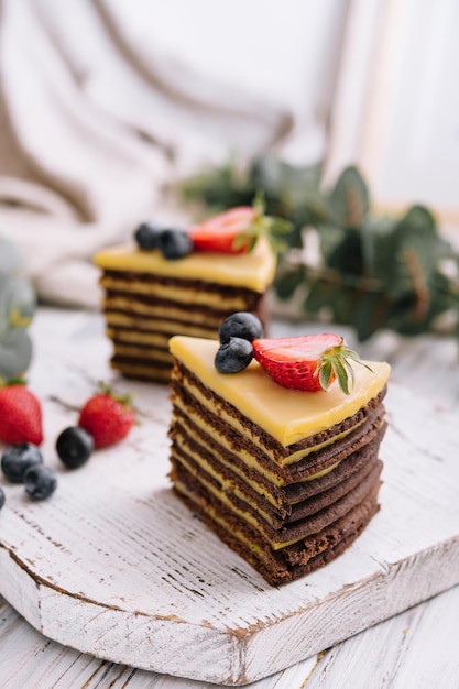 Deliziosa torta al cioccolato fresca con frutti di bosco sulla tavola di legno