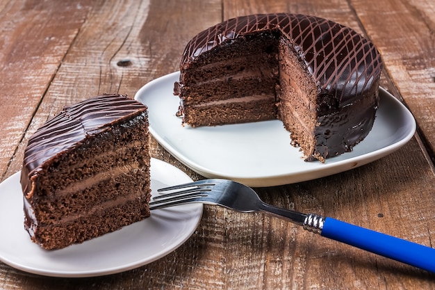 Deliziosa torta al cioccolato su un piatto sotto fondo in legno.