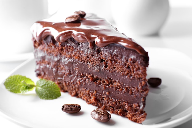 Deliziosa torta al cioccolato sul piatto sul tavolo su uno sfondo chiaro