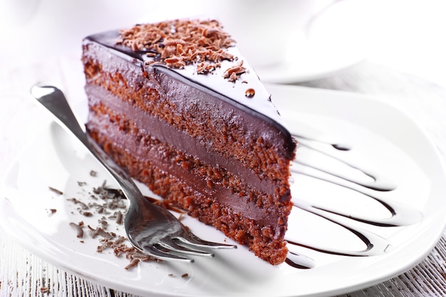Deliziosa torta al cioccolato sul piatto sul tavolo sul tavolo di legno bianco