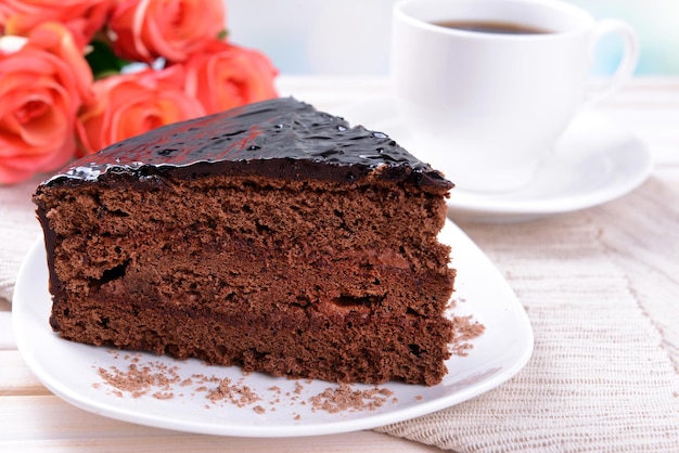 Deliziosa torta al cioccolato sulla piastra sul tavolo su sfondo chiaro