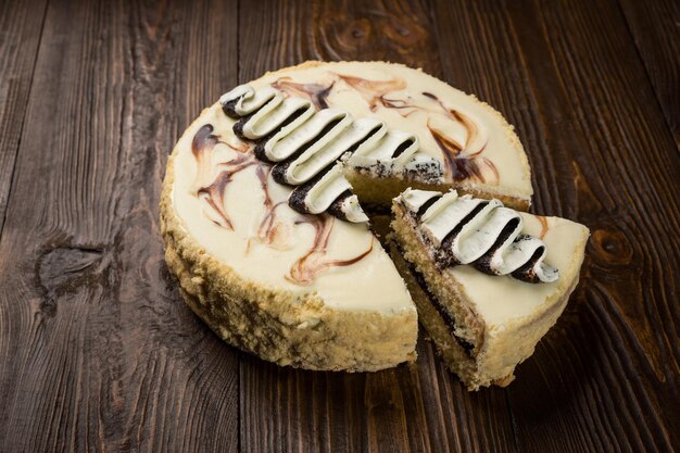 Deliziosa torta al cioccolato vegana con crema e semi di papavero su fondo di legno scuro