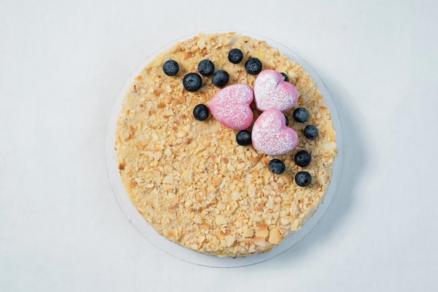 Deliziosa torta con noci di mora fresca e cuori rosa sul tavolo bianco vista orizzontale