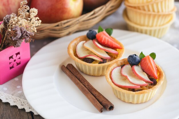 Deliziosa torta di caramello fatta in casa con mele cotte e decorato con fragole e mirtilli a fette.