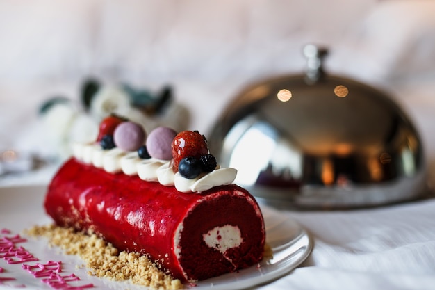 Deliziosa torta di compleanno sul letto con romantici fiori di rosa