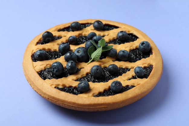 Deliziosa torta di mirtilli con frutti di bosco su violetta