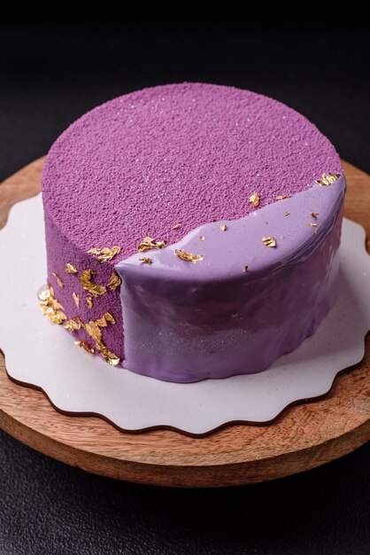 Deliziosa torta di mousse dolce e fresca con ripieno di bacche coperta di velluto rosa su uno sfondo di cemento scuro
