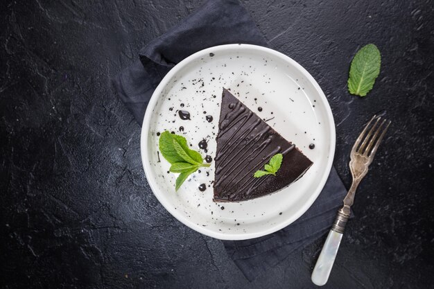 Deliziosa torta di Praga al cioccolato su piastra su sfondo scuro, vista dall'alto