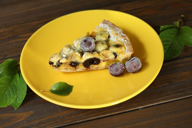 Deliziosa torta di quiche con ripieno di ciliegie su piatto giallo