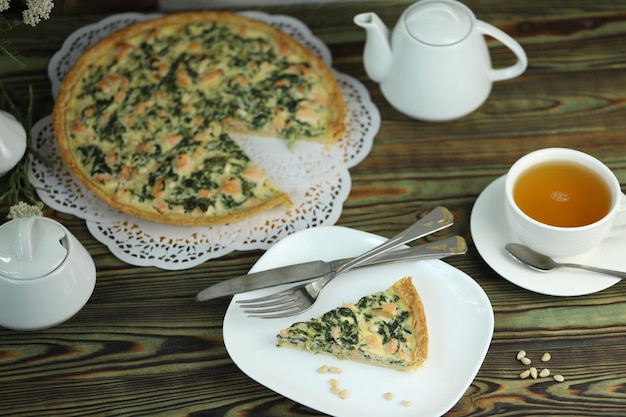 Deliziosa torta di quiche con salmone e noci di pino a riempimento Colazione con quiche e una tazza di tè