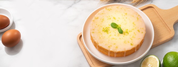 Deliziosa torta di spugna di libbra glassata al limone su sfondo di tavolo in marmo bianco