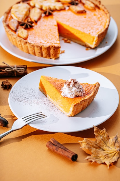 Deliziosa torta di zucca del Ringraziamento fresca fatta in casa con una fetta a fette pronta per essere mangiata