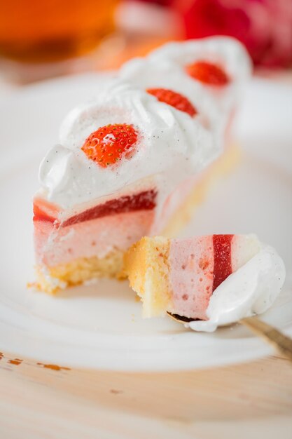 Deliziosa torta dolce da vicino torta a fuoco selettivo con crema proteica bianca decorata con fragole mousse fragola souffle