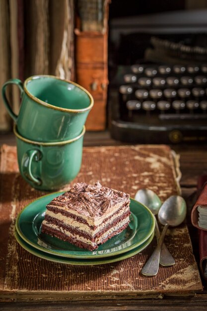 Deliziosa torta e caffè con libri e macchina da scrivere