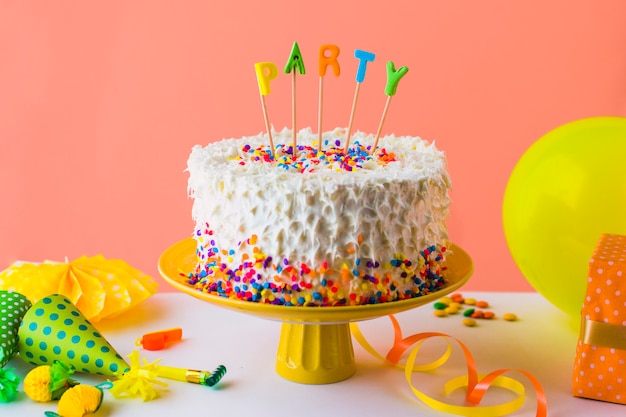 Deliziosa torta festa con accessori sul piano del tavolo bianco