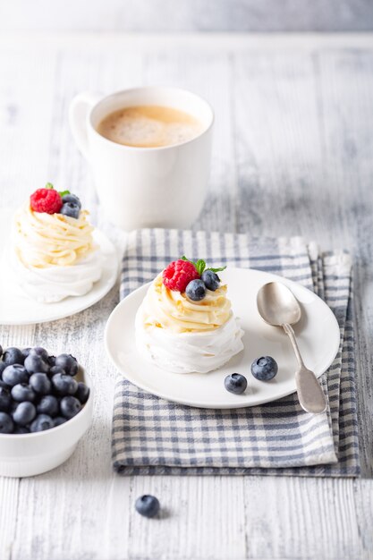 Deliziosa torta Pavlova con panna montata e frutti di bosco freschi