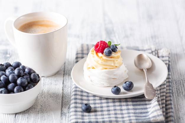 Deliziosa torta Pavlova con panna montata e frutti di bosco freschi