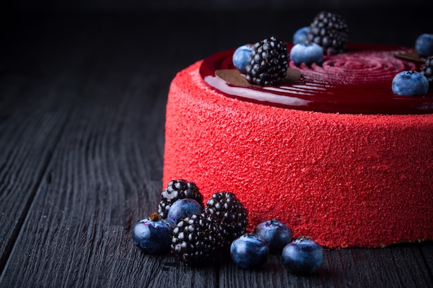 Deliziosa torta rosa con frutti di bosco sul tavolo di legno