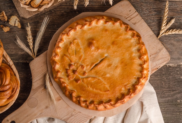 Deliziosa torta rotonda fresca farcita con decorazioni di pasta riccia su fondo in legno