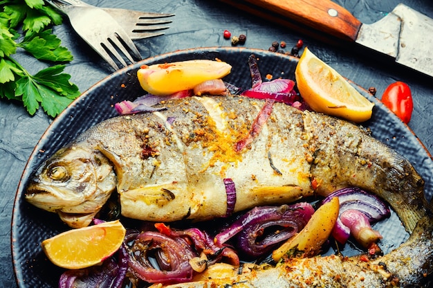 Deliziosa trota di fiume fritta con cipolla e limone. Trota iridea al forno, frutti di mare