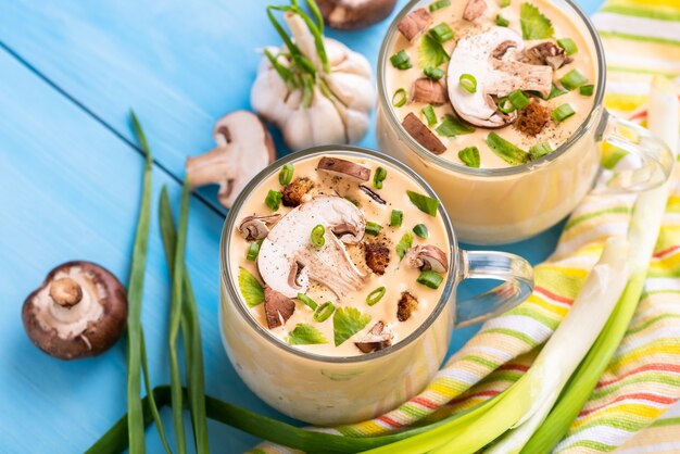 Deliziosa zuppa di funghi con cipolla e aglio su uno spazio di legno