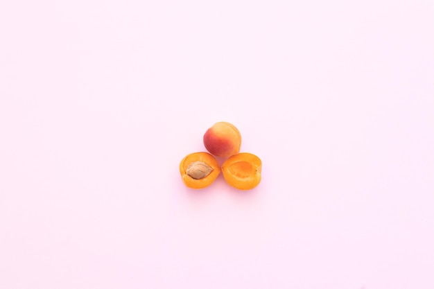 Deliziose albicocche dolci mature su sfondo rosa piatto