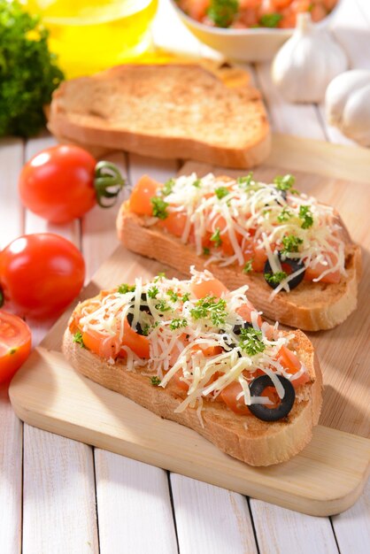 Deliziose bruschette con pomodori sul primo piano del tagliere