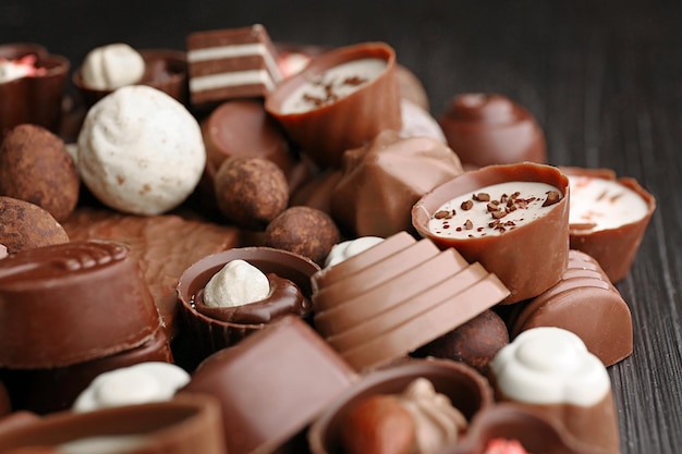 Deliziose caramelle al cioccolato su fondo di legno si chiuda