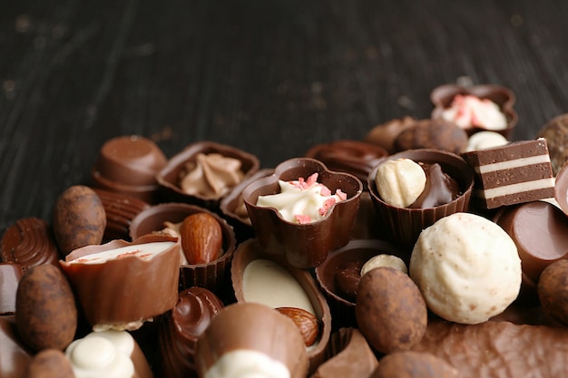 Deliziose caramelle al cioccolato su fondo in legno