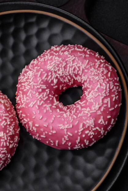 Deliziose ciambelle dolci fresche in glassa rosa con ripieno di fragole