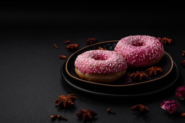 Deliziose ciambelle dolci fresche in glassa rosa con ripieno di fragole