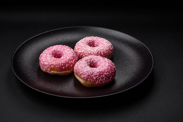 Deliziose ciambelle dolci fresche in glassa rosa con ripieno di fragole