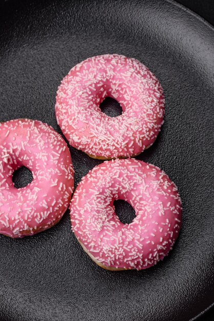 Deliziose ciambelle dolci fresche in glassa rosa con ripieno di fragole