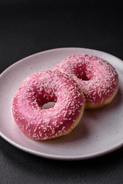 Deliziose ciambelle dolci fresche in glassa rosa con ripieno di fragole