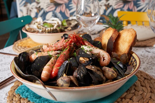 Deliziose cozze di pesce con gamberi e pane tostato Vongole con i gusci pronte da mangiare Vista frontale Concetto di cibo