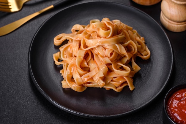 Deliziose e appetitose tagliatelle di pasta al sugo di pomodoro e parmigiano