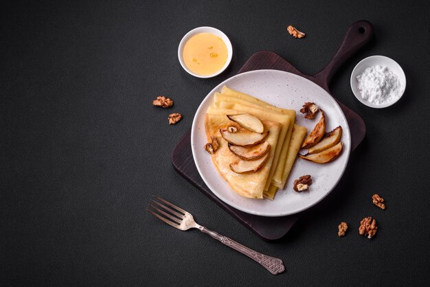 Deliziose frittelle appena sfornate con miele e frutta su uno sfondo concreto