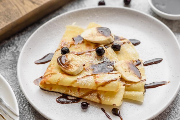 Deliziose frittelle appena sfornate con miele e frutta su uno sfondo di cemento testurizzato Utile cibo sano