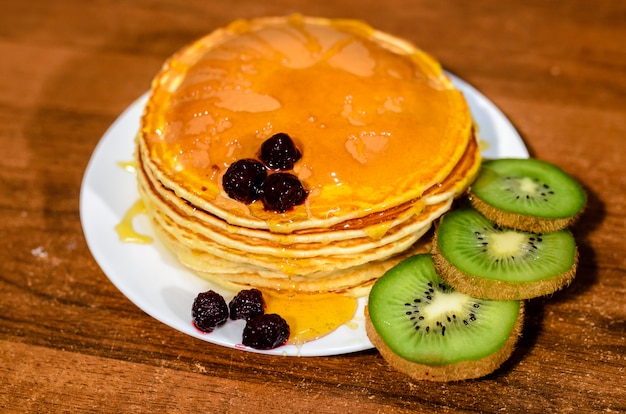 Deliziose frittelle con miele, kiwi e frutti di bosco.