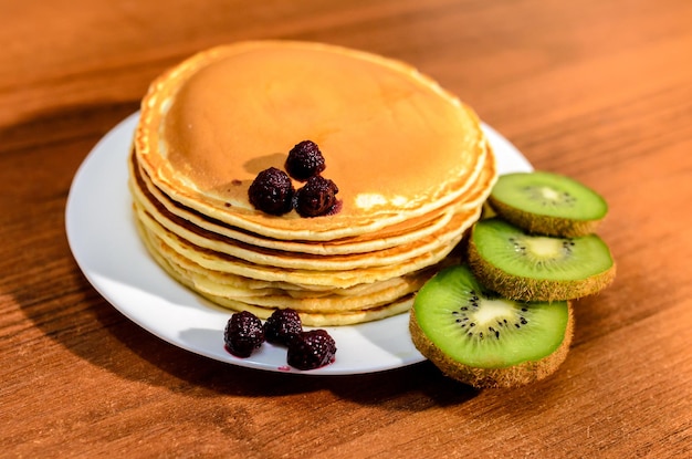 Deliziose frittelle con miele, kiwi e frutti di bosco.