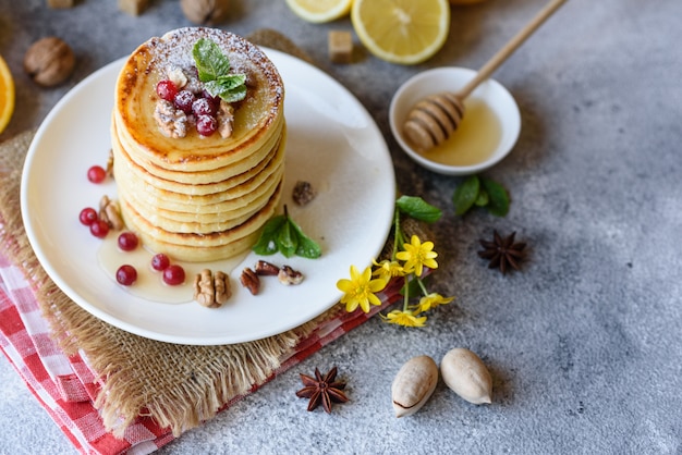 Deliziose frittelle fresche deliziose con miele di agrumi e marmellata. Deliziosa colazione calda con pancake con frutta e bacche