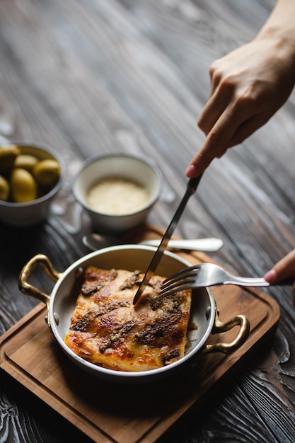 Deliziose lasagne con olive grandi su fondo scuro. Fotografia di cibo