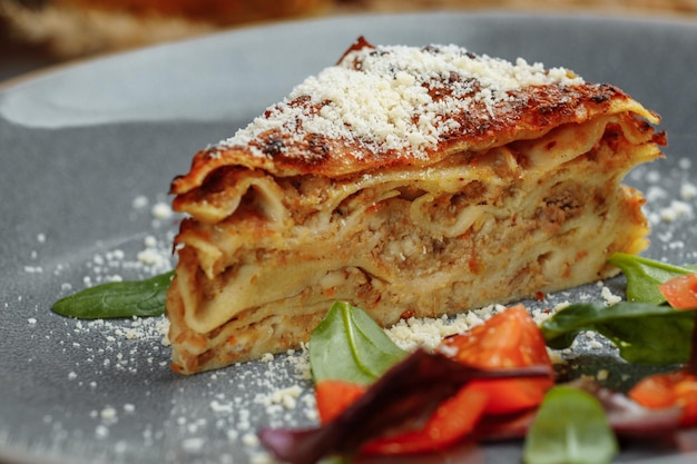 Deliziose lasagne di carne fatte in casa con foglia di basilico in alto primo piano menu ricetta lato cucina italiana
