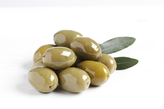 Deliziose olive verdi con foglie isolate su bianco