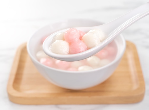 Deliziose palline di gnocchi di riso rosso e bianco tang yuan in una piccola ciotola cibo festivo tradizionale asiatico per il festival cinese del solstizio d'inverno primo piano